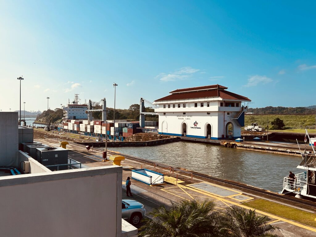 Scenic view of the Miraflores Locks at Panama Canal with cargo ship on a sunny day.